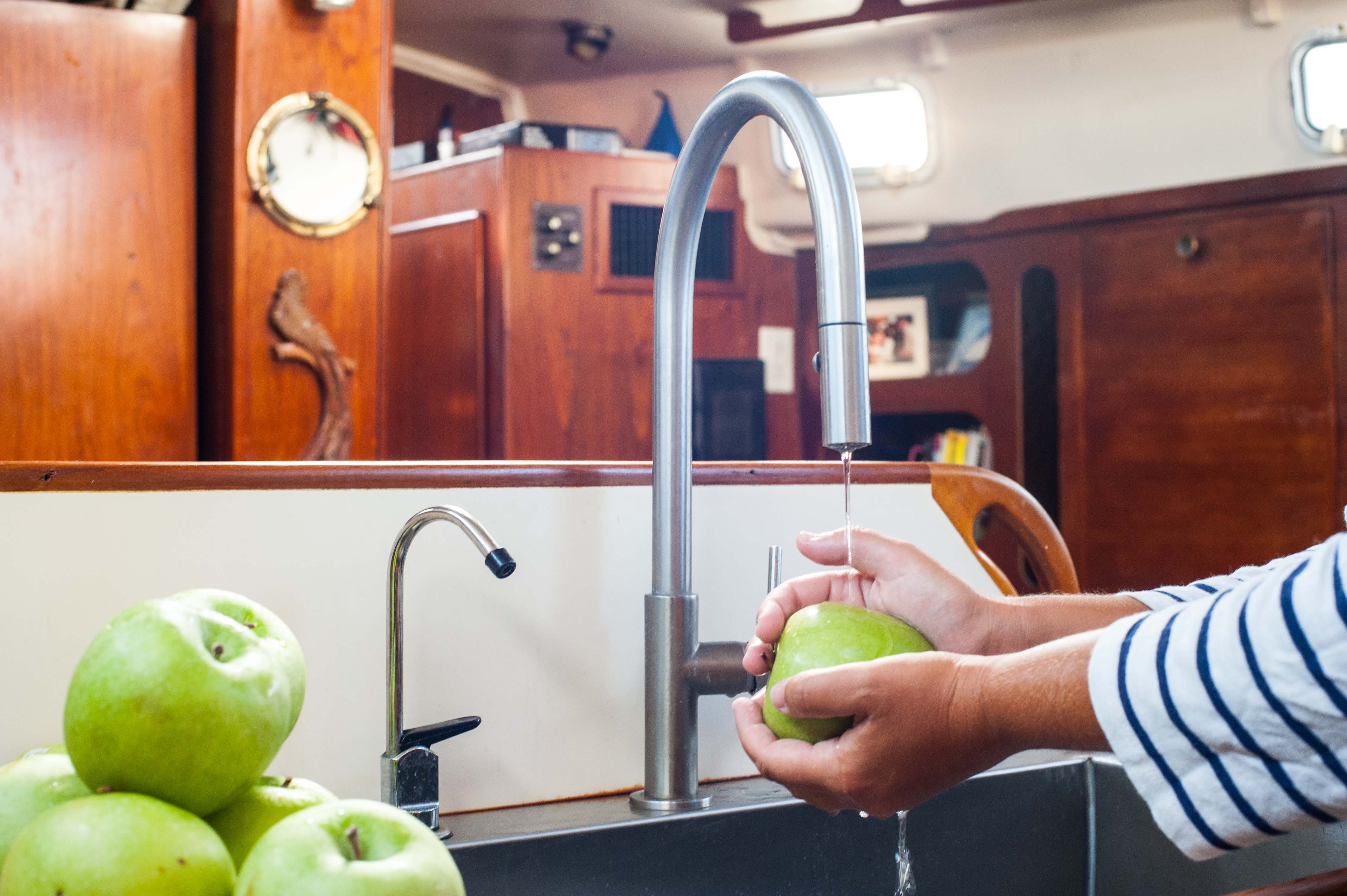 Washing apples in galley sink on sailboat