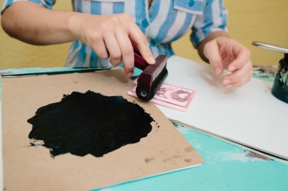 rolling ink from a brayer onto a diy linoleum stamp