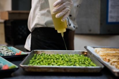 oil drizzled over peas in a professional kitchen