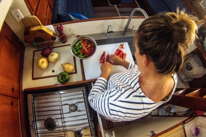 woman cooking and chopping in galley kitchen