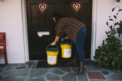 Tiffany Bess swaps empty and full compost buckets at a residence.