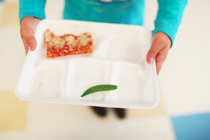 child holding lunchroom tray 