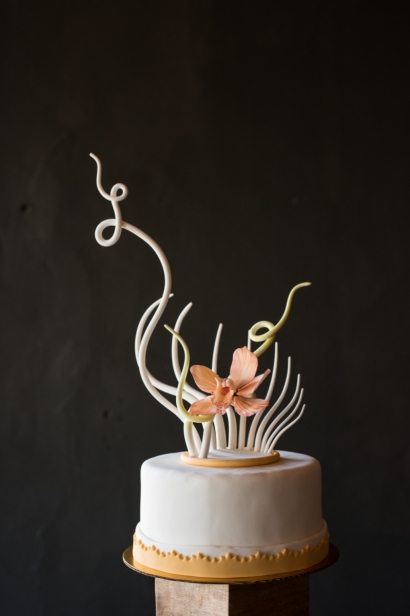 intricate, edible sugar flower and sculpture on top of cake