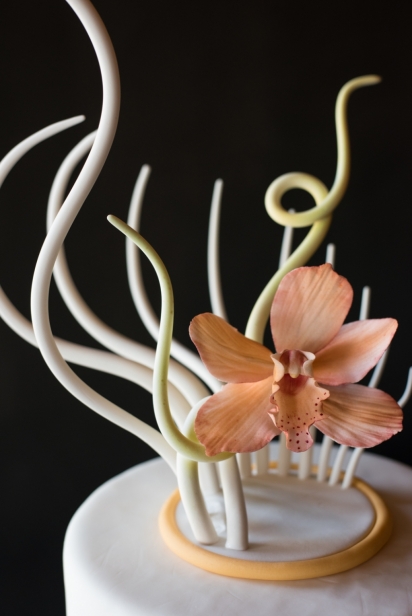 intricate, edible sugar flower and sculpture on top of cake 