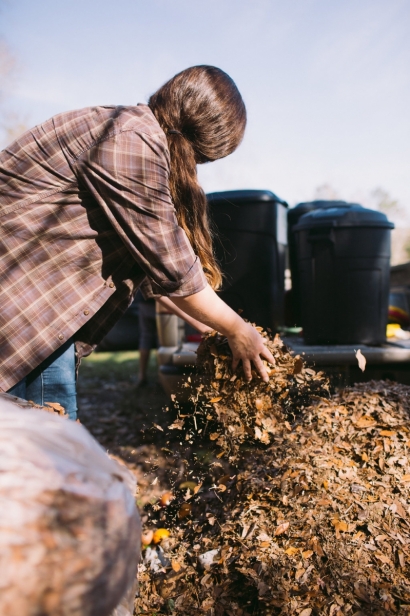 Tiffany Bess adding leaves to compost pile