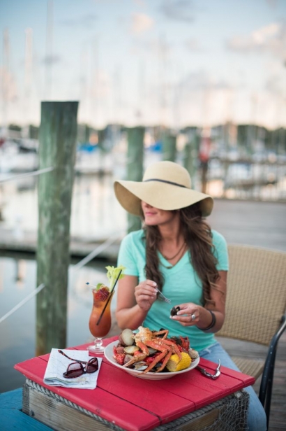 woman enjoying a meal by the water
