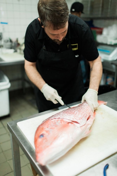 florida red snapper being prepared by cook at taverna san marco in jacksonville florida