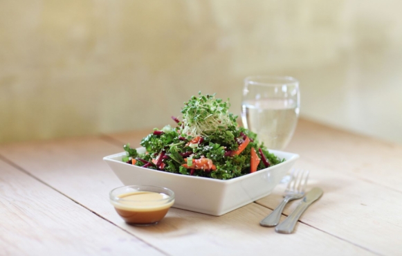 Kale salad with citrus dressing on wood table