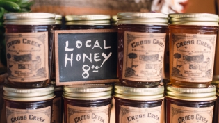 cross creek honey jars and sign at community loaves in jacksonville
