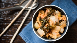 Fermented Kimchi in bowl with chop sticks