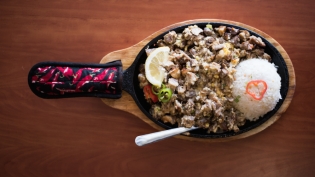 pork sisig on a sizzling plate with rice
