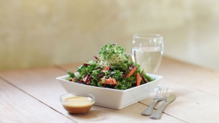 Kale salad with citrus dressing on wood table